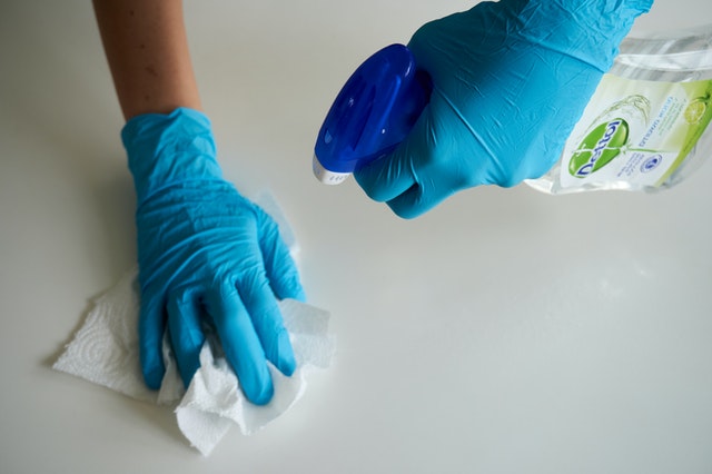 Addetto alla sanificazione che utilizza prodotti detergenti